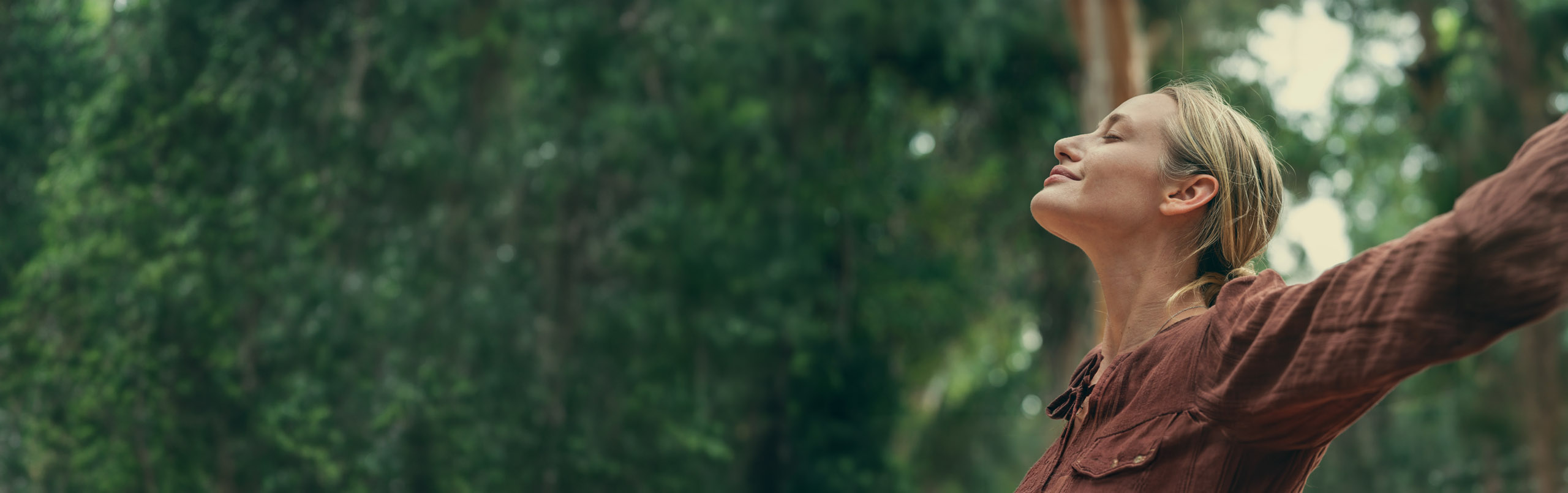 Woman breathing deeply outdoors, representing LAM patient quality of life